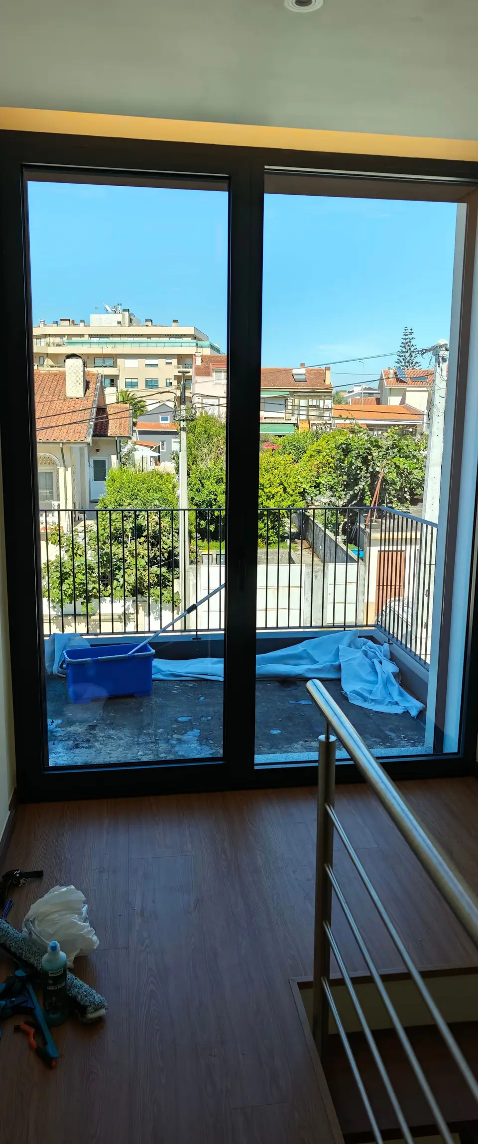 Porta de vidro para o terraço de um quarto, limpa, com vista sobre os telhados